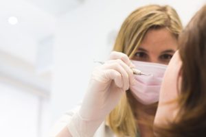 Female dentist looking at patient's teeth